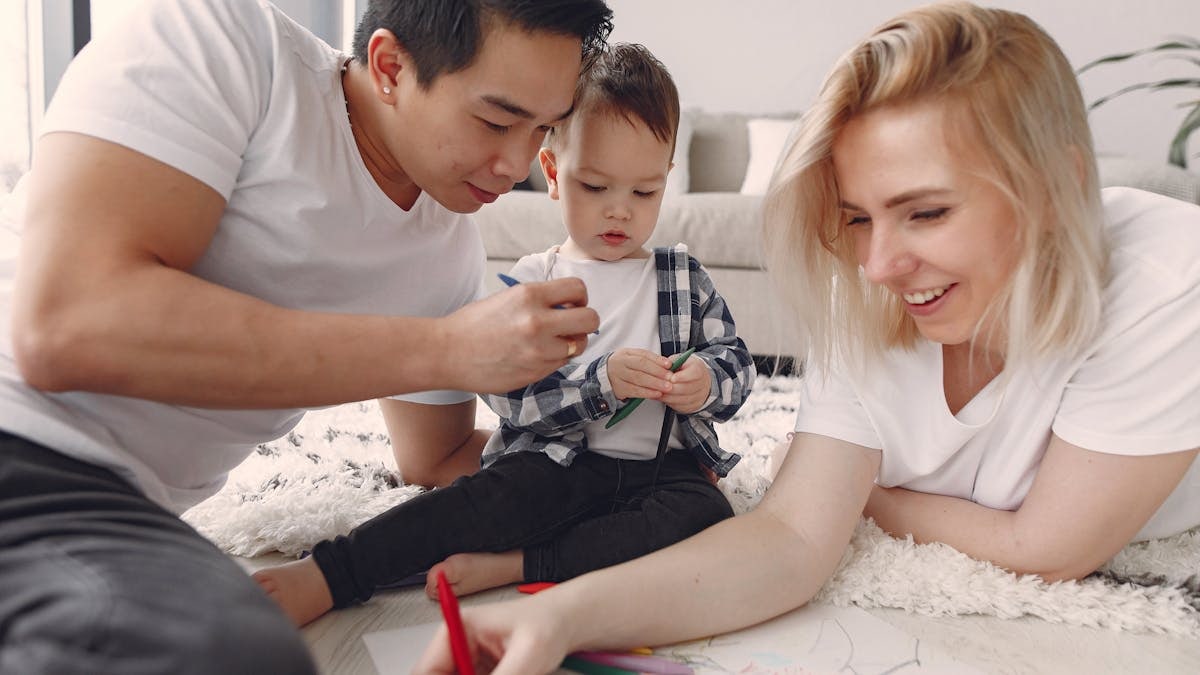 A joyful family engaged in creative arts and crafts indoors, fostering togetherness and creativity.